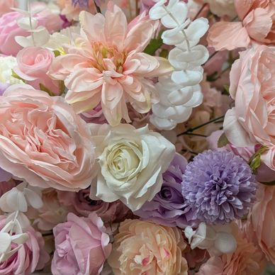 A vibrant bouquet of pastel-colored artificial flowers in pink, purple, and white hues.