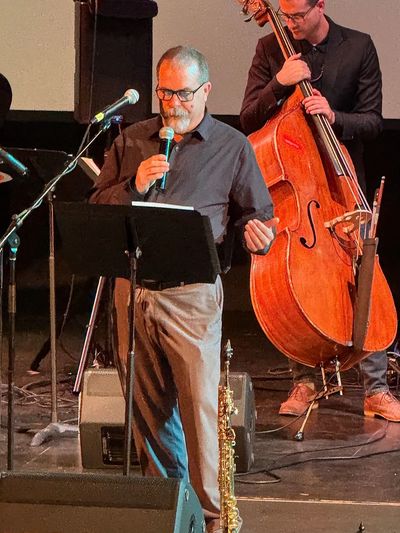 Man singing and musician playing double bass on stage.