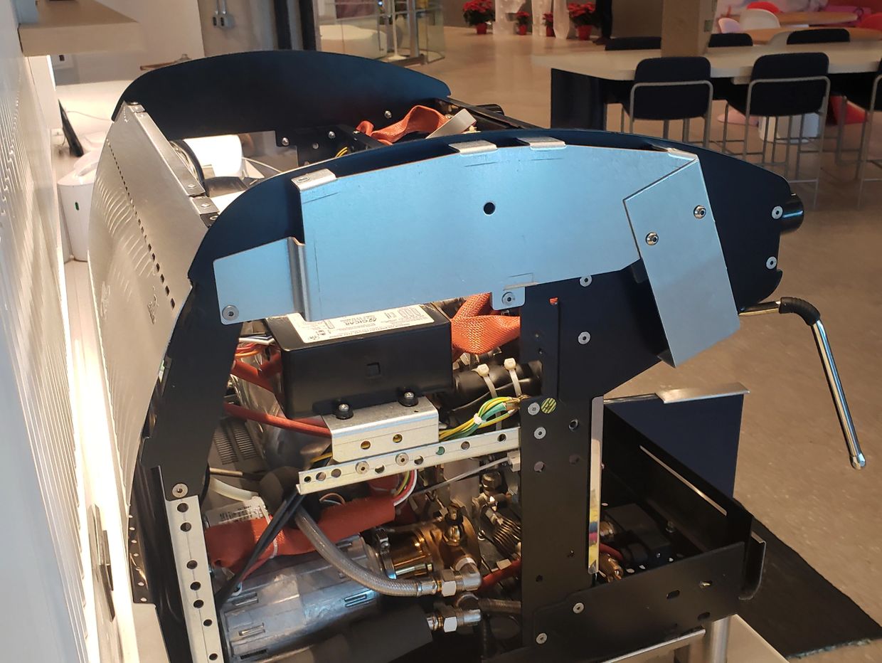 Partially disassembled espresso machine showing internal components on a counter.