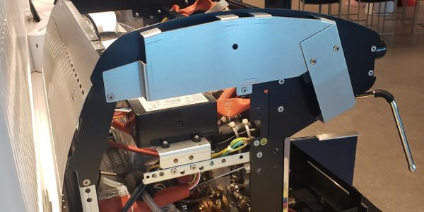 Partially disassembled espresso machine showing internal components on a counter.