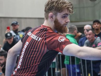 Man with a beard reaching out during a sports event.