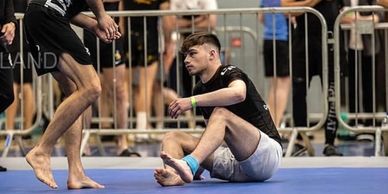 Athlete sitting on the ground during a match.