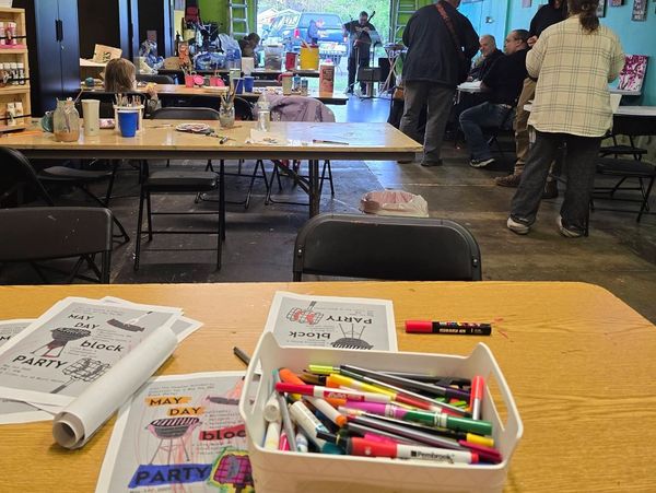 Art supplies and coloring sheets on a table in a creative workshop space.
