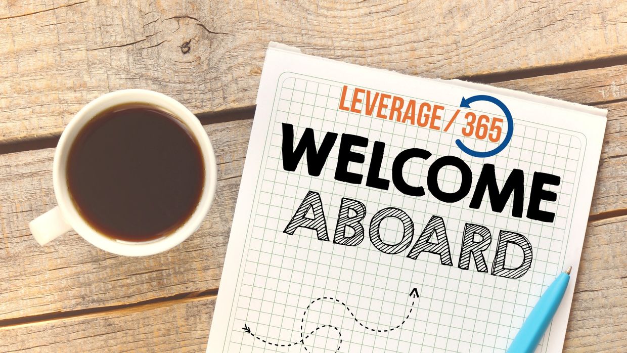 Cup of coffee next to a welcome aboard note on a wooden table.