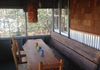 Custom Porch-Hand crafted live edge oak table, reclaimed joist bench, corrugated steel wainscoting and shingles. 