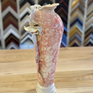 Unique pink and cream ceramic vase with organic, flowing design.