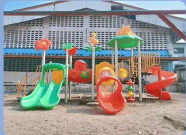 Colorful playground with slides and climbing structures under a large building.