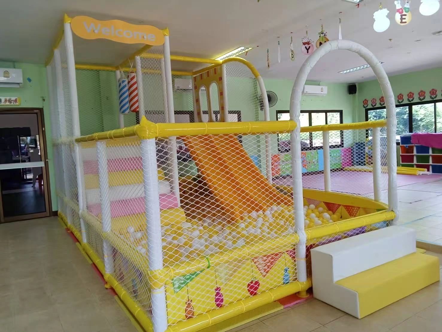 Indoor children's play area with a yellow slide and ball pit.