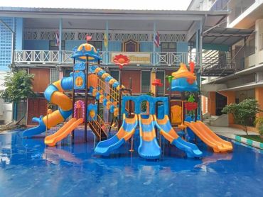 Colorful playground with multiple slides and climbing structures on a blue surface.