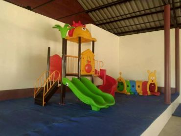 Indoor playground with colorful slides and play tunnels.