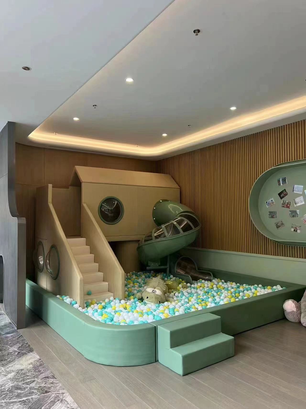 Modern indoor playground with ball pit, slide, and cozy design.
