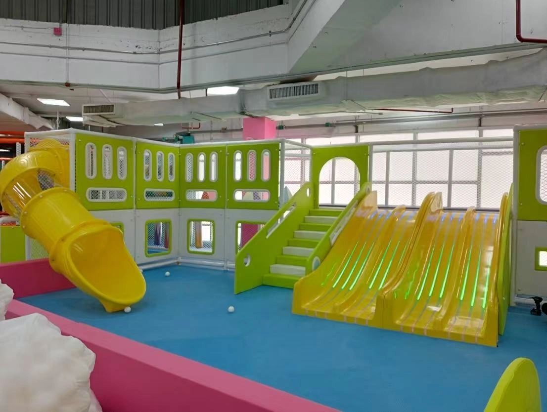 Indoor playground with yellow slides and blue flooring.