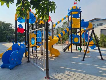 Colorful children's playground with slides and climbing structures under bright sunlight.