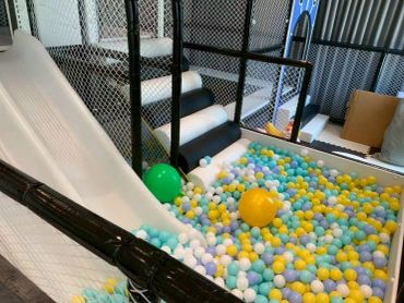 Indoor play area with slide and colorful ball pit.