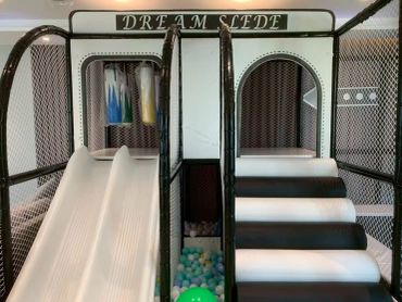 Indoor play structure with slides and ball pit for kids.