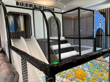 Indoor children's play area with slides and ball pit.