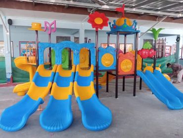 Colorful playground with multiple slides and climbing structures indoors.