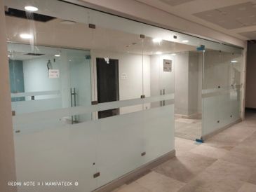 Modern office space with glass partitions and frosted panels.