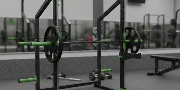 Empty gym rack with weights and barbell ready for lifting.