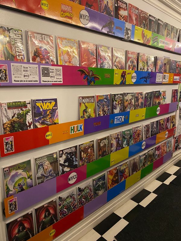 Colorful comic book display with Marvel titles on a wall.