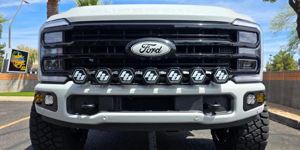 Front view of a white Ford truck with multiple auxiliary lights.
