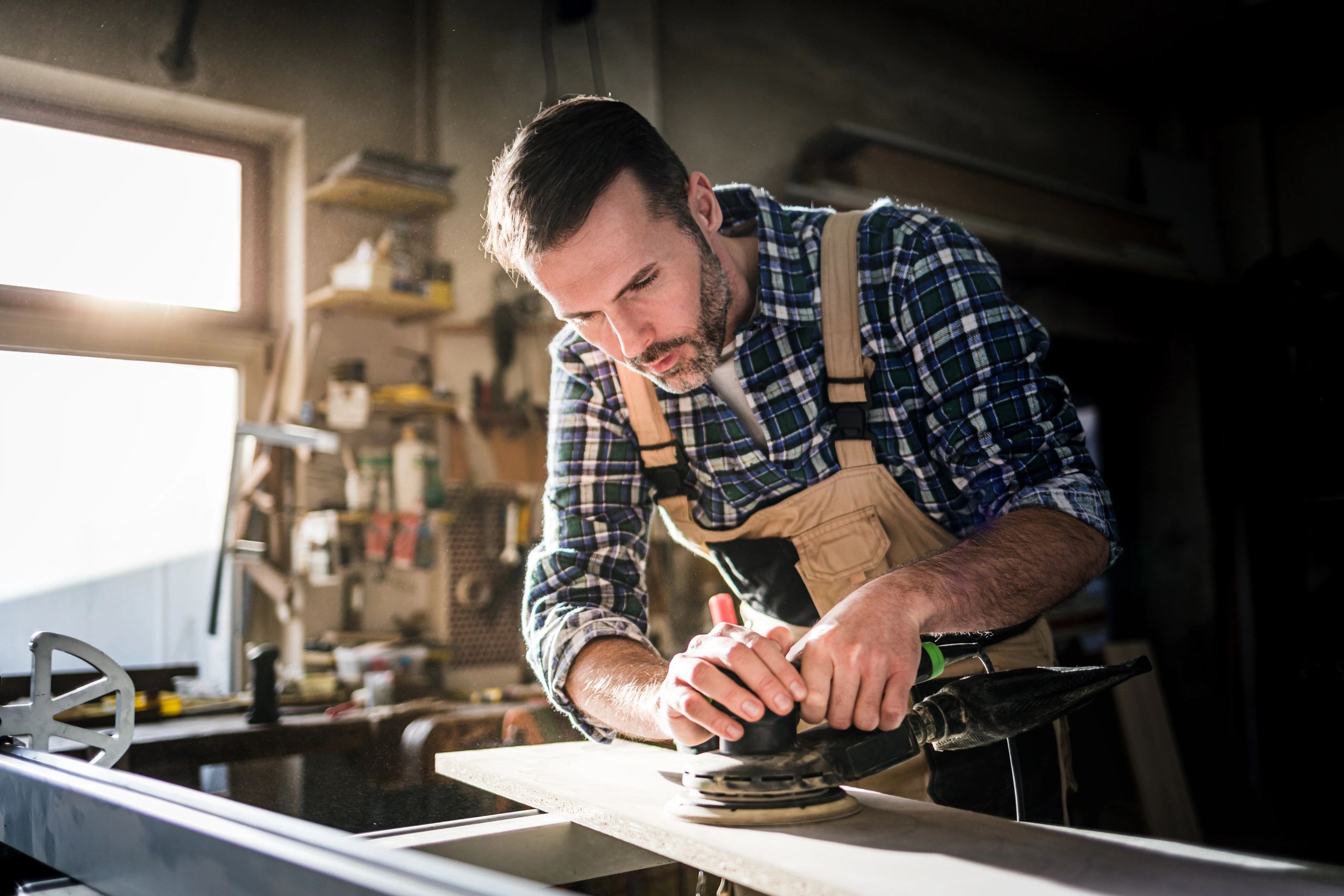 Carpenter working carefully with a hand tool.