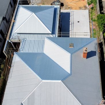Aerial view of a grey metal roof with multiple sections.