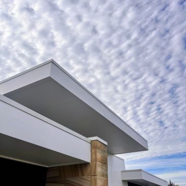 Modern building roof against cloudy sky.