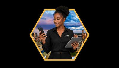 Mulher negra sorrindo segurando celular e tablet.