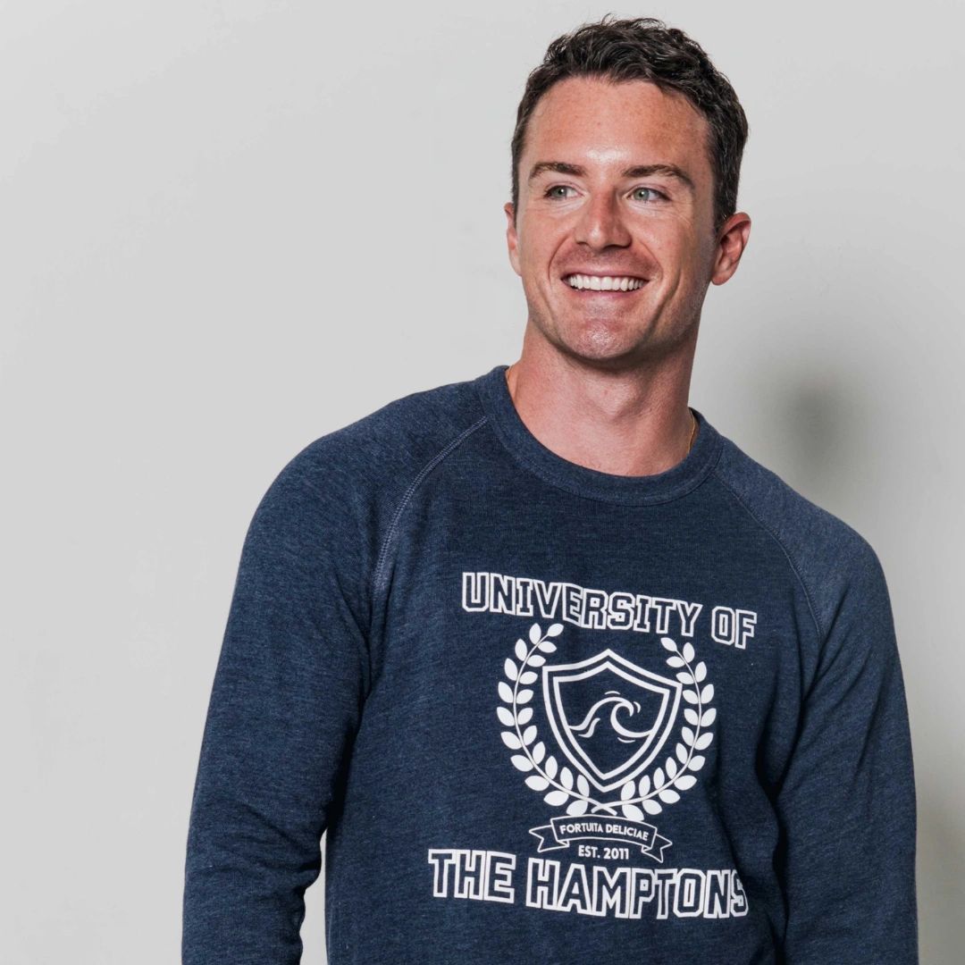 Smiling man wearing a navy sweatshirt with 'University of The Hamptons' text.