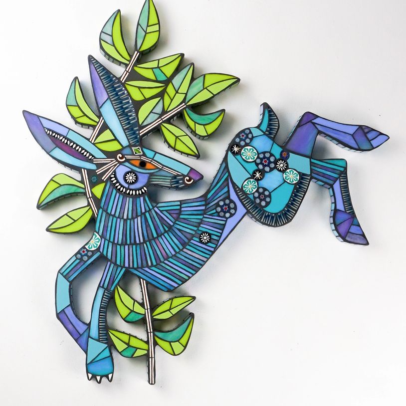 Colorful mosaic deer with green leaves on white background.
