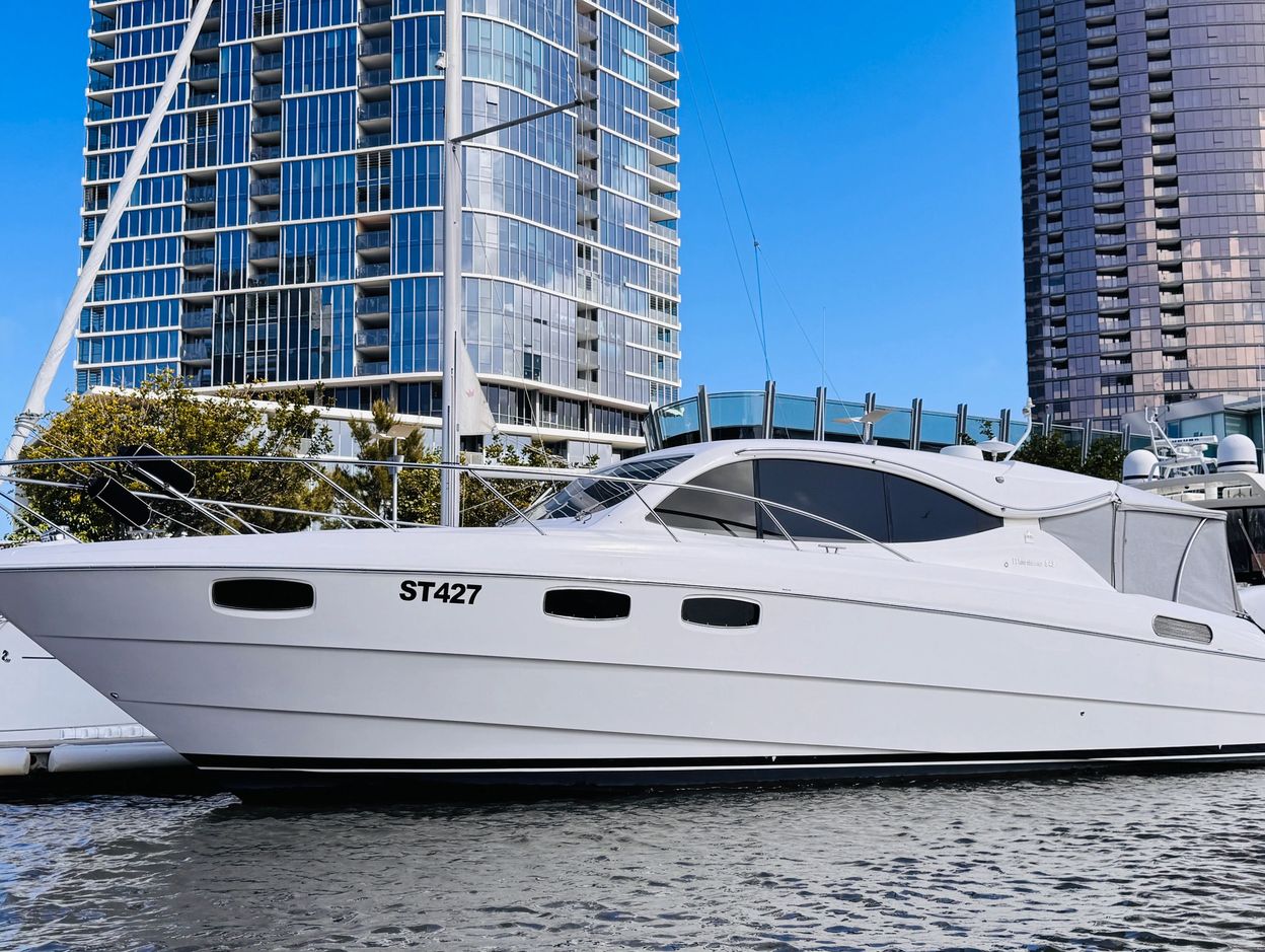White luxury yacht docked in city marina.