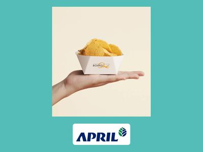 Hand holding a paper food tray with chips.