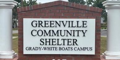 Greenville Community Shelter sign on brick structure.