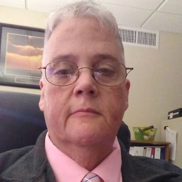 Man with glasses in a formal outfit.