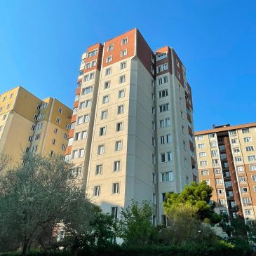Çok katlı apartman ve mavi gökyüzü.