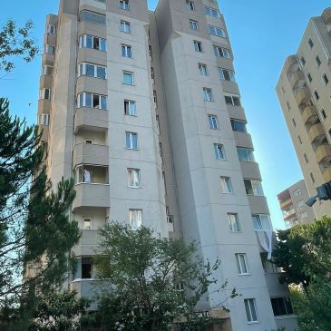 Çok katlı bir apartman binası ve ağaçlar.