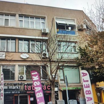 Üç katlı bina ve önünde pankartlar