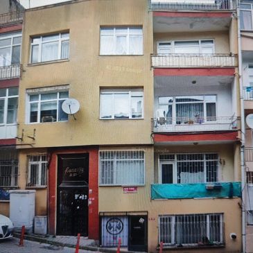 Üç katlı apartman dış görünümü.