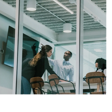 A group of HR professionals engaged in a discussion in a modern conference room with glass walls.