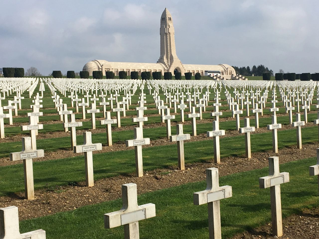 Sad cemetery in Verdun, with the stark and haunting Douaumont Ossuary in the background. 