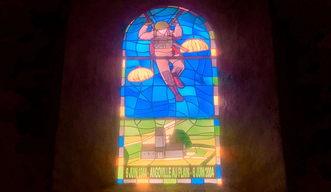 Angoville au Plain: Paratroopers fall from the sky in this stained glass window found in a tiny Norman village church, not far from Utah Beach. Angoville au Plain: Paratroopers fall from the sky in this stained glass window found in a tiny Norman village church, not far from Utah Beach.