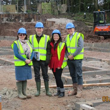 Four people with high-viz jackets on a building site