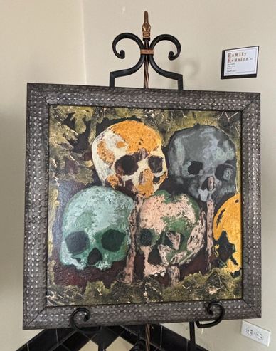 Painting of five colorful skulls in a textured frame.