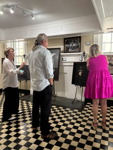People observing art pieces in a gallery.