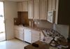 Before: 80's Kitchen with sink in corner, bleached oak cabinets and angled range