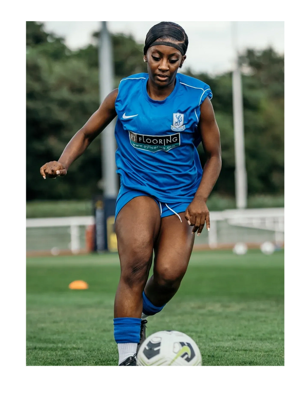 Image shows a footballer dribbling a football.