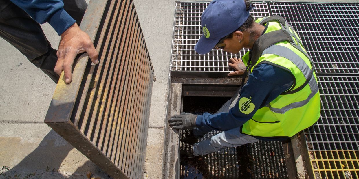 Trabajador de ABP realizando labores de mantenimiento de una boca de tormenta,