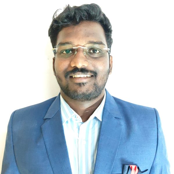 Man with glasses wearing a blue blazer and striped shirt.