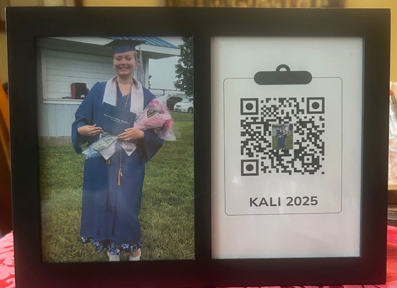 Framed photo of a graduate in cap and gown next to a QR code labeled KALI 2025.